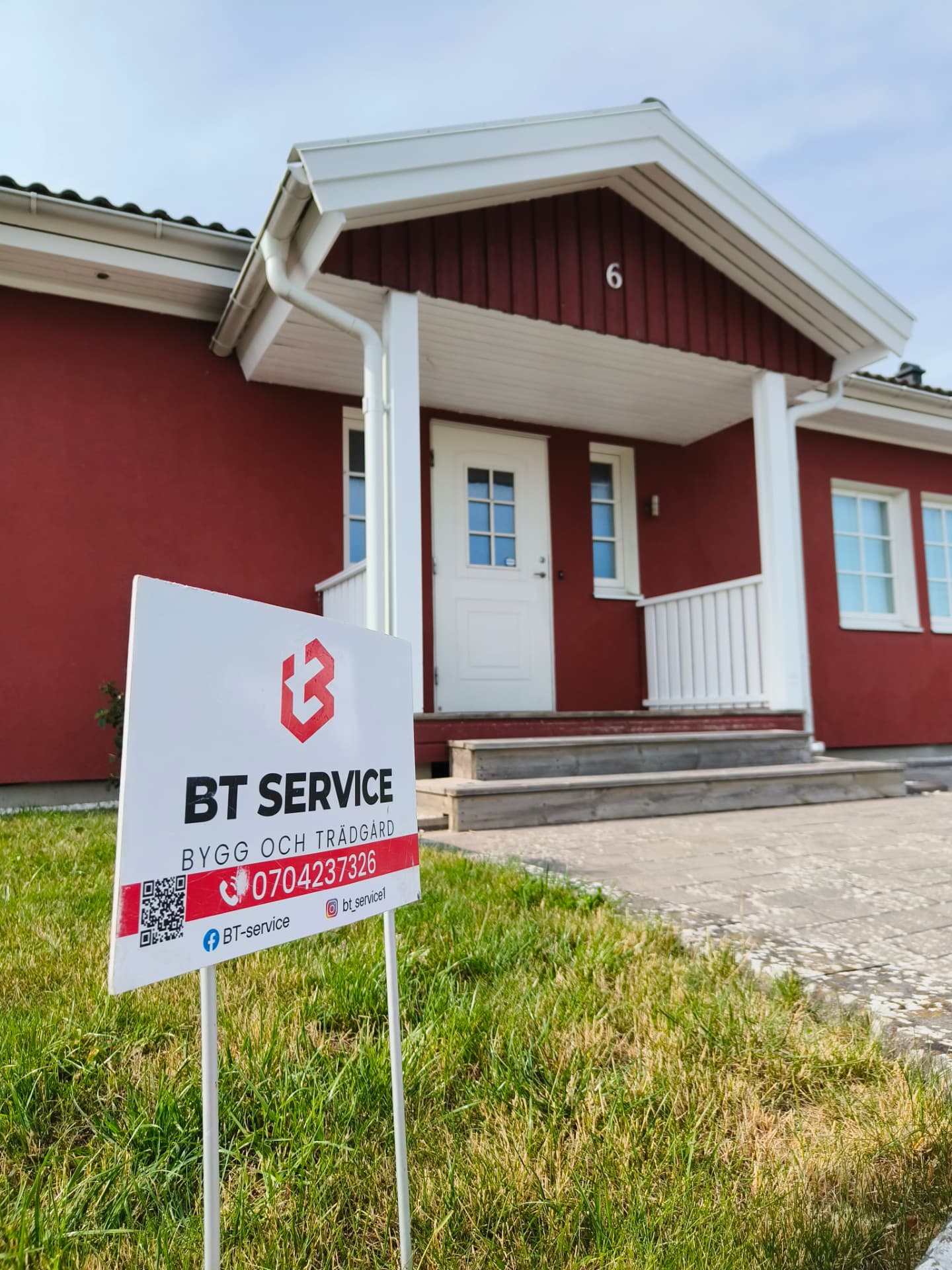 BT-Service skylt på gräsmattan framför ett rött hus i Skåne under pågående projekt